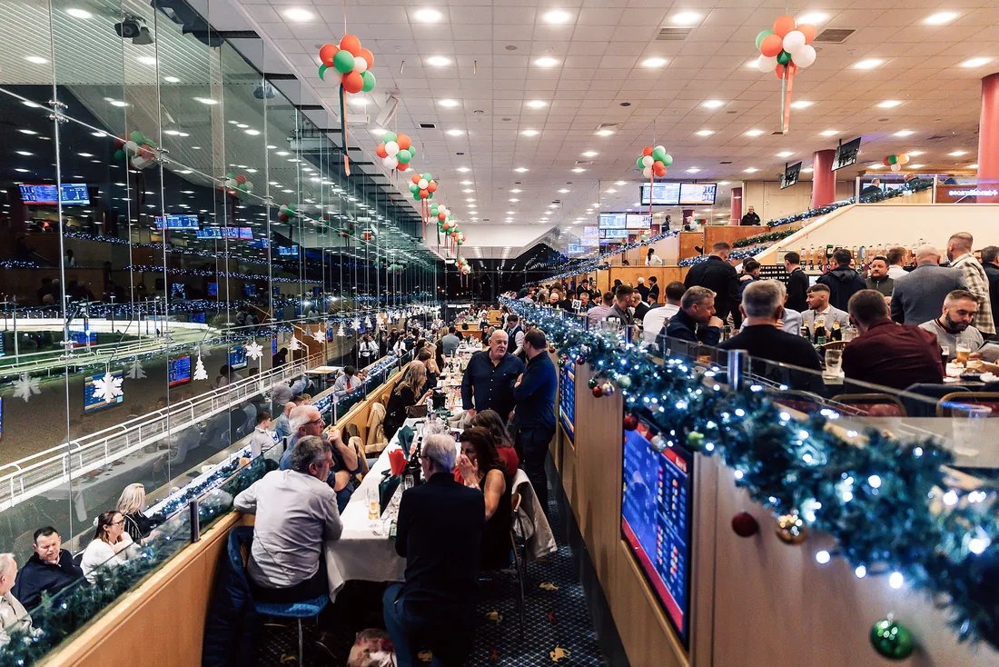A long Christmas table in the restaurant above the floodlit track
