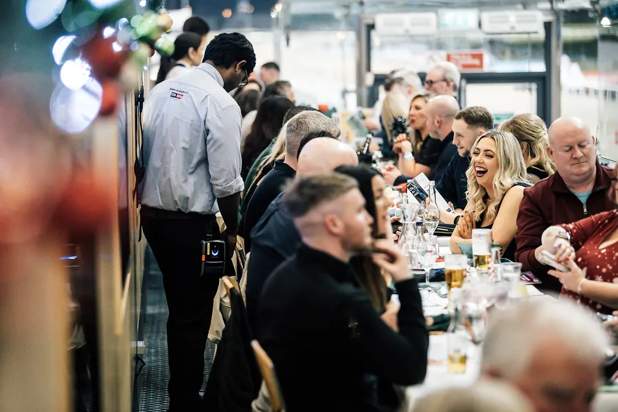 A Christmas party group laughing at their table